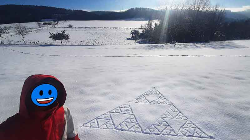 Um triângulo fractal de Sierpiński desenhado na neve.